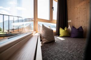 ein Zimmer mit Kissen vor einem Fenster in der Unterkunft Hotel Simpaty in Toblach