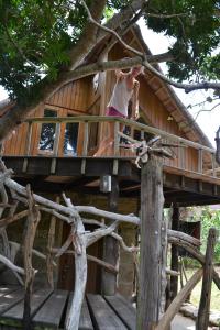 a girl on a skateboard on the deck of a tree house at Driftwood Treehouse in Sunrise-on-Sea