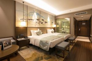 Postel nebo postele na pokoji v ubytování Millennium Resort Wuyishan