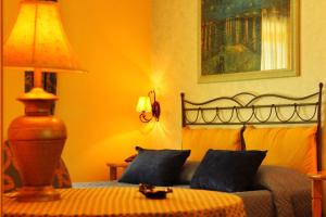 Schlafzimmer mit einem Bett und einer Lampe auf einem Tisch in der Unterkunft Blu Tropical Resort in Zambrone