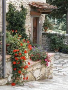 um edifício de pedra com flores em frente a uma porta em Foresteria Castello di Verrazzano em Greve in Chianti