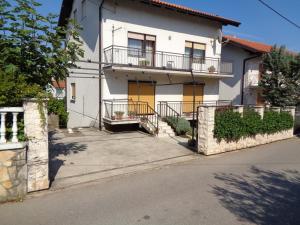 a white house with yellow doors and a balcony at Nena's Place in Rijeka