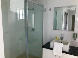 a bathroom with a shower, sink, and toilet at Kalidonis Village in Darwin