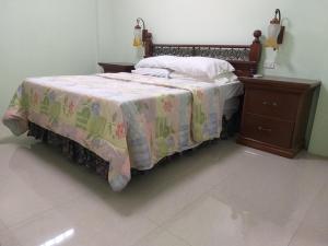 a bedroom with a bed and a wooden dresser at Dweller's Pensione in Iloilo City