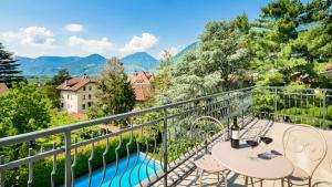a balcony with a table and chairs and a pool at Hotel Villa Laurus in Merano