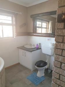 a bathroom with a black toilet and a sink at Sunflower Self-Catering in Walvis Bay +51 photos
