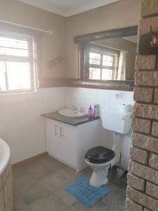 a bathroom with a black toilet and a sink at Sunflower Self-Catering in Walvis Bay