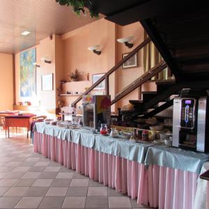 a long table in a kitchen with pink table cloth at Hotel Alpi Del Mare in Mondovì