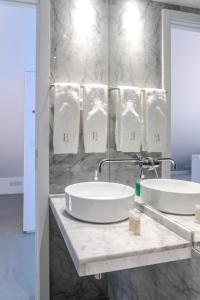 two sinks in a bathroom with white marble walls at Sta Catarina Design Apartments by Lisbon One in Lisbon