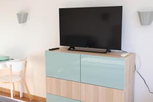 TV de pantalla plana en la parte superior de un tocador en Ericeira Sea&Sun Apartment 2, en Ericeira