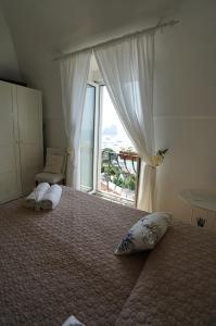 sypialnia z łóżkiem i dużym oknem w obiekcie La Finestra sui Faraglioni w mieście Capri