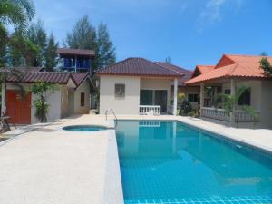 a swimming pool in front of a house at Khaolak Summer House Resort in Khao Lak