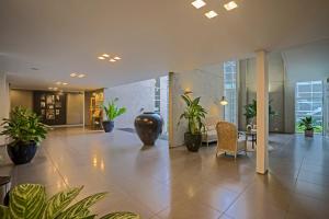 a lobby with potted plants in a building at Malaka Hotel Bandung in Bandung