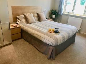 a bed with a tray of oranges and drinks on it at Waterside Lodges Cambridge in Cambridge