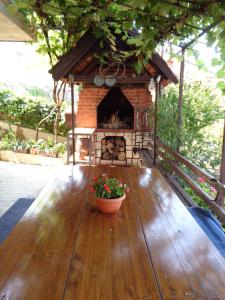 a patio with a brick fireplace on a wooden deck at Nena's Place in Rijeka