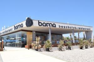 a barona restaurant with palm trees in front of it at TAIGA Delta de l'Ebre in L'Ampolla