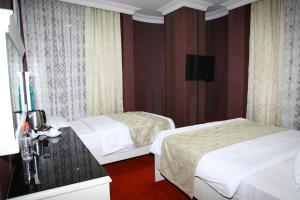 a hotel room with two beds and a television at Ens Hotel in Istanbul