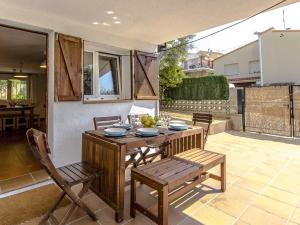 a wooden table and chairs on a patio with a table and chairs at Can Pinemar in Pineda de Mar