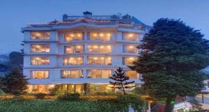 a large building with many windows and a tree at Hotel Viceroy in Darjeeling