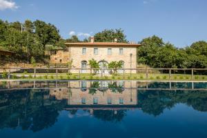 a house with a reflection in the water at Villa Mezzavia in Cortona