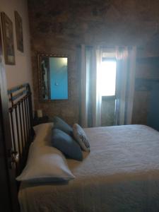 a bedroom with a bed with blue pillows and a window at Casa Carola in Oia