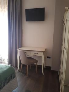 a desk in a bedroom with a chair and a television at Casale degli Ulivi in Cirò Marina