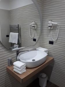 a bathroom with a sink and a mirror and towels at Casale degli Ulivi in Cirò Marina
