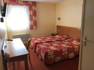 Cette chambre comprend 2 lits et une table. dans l'établissement Hôtel La Colombiere Cantal, à Massiac