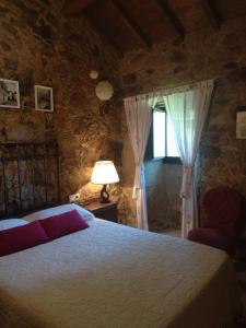 a bedroom with a bed and a lamp and a window at Casa Carola in Oia