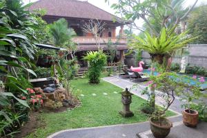 a garden with plants and a house with a pink flamingo at Ubud Sensasi Bungalow in Ubud