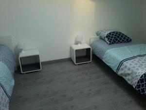 1 dormitorio con 2 camas y 2 altavoces en el suelo en Gîte climatisé *** Le Pigeonnier, en Pons