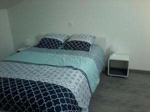 Un dormitorio con una cama con sábanas y almohadas azules y blancas en Gîte climatisé *** Le Pigeonnier, en Pons