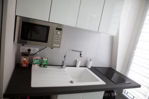 a kitchen with a sink and a microwave at Studio Tour Eiffel in Paris