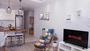 Il comprend un salon avec une télévision et une cuisine. dans l'établissement Cozy home in Thessaloniki center, à Thessalonique