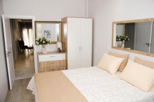 塞薩羅尼基的住宿－Cozy home in Thessaloniki center，白色卧室配有床和镜子