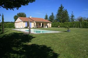 a house with a swimming pool in a yard at Le Camp De Ferie in Monpazier