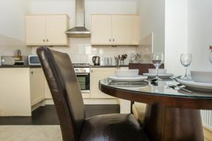 uma cozinha com mesa e cadeiras e uma cozinha com armários brancos em No 5 - Central - by Brighton Holiday Lets em Brighton & Hove