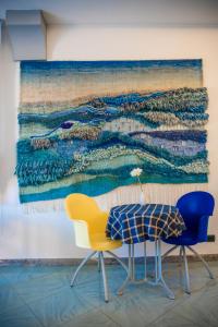 a table and two chairs in front of a painting at Riviera Residence in Marina di Pietrasanta