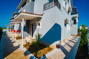 a white house with a porch and a balcony at Belek Akropolis Medusa Otel in Belek