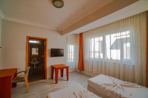 a hotel room with a bed and a desk and a window at Belek Akropolis Medusa Otel in Belek