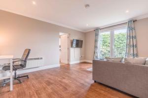 a living room with a couch and a desk at Modern apartment within short walk of The Castle, High Street and Long Walk - FREE PARKING in Windsor