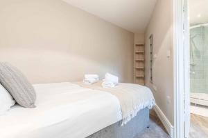 um quarto com uma cama grande e uma casa de banho em Modern apartment within short walk of The Castle, High Street and Long Walk - FREE PARKING em Windsor
