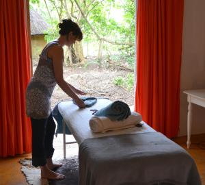 una donna in piedi accanto a un letto in una stanza di Driftwood Treehouse a Sunrise-on-Sea