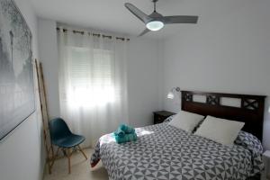 1 dormitorio con 1 cama y 1 silla azul en Sanlúcar Apart Airen!!, en Sanlúcar de Barrameda