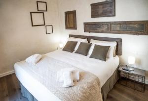 a bedroom with a large white bed with two pillows at La Canonica - charming self-catering apartments in Nizza Monferrato in Nizza Monferrato