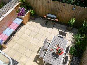 een patio met een tafel en stoelen bij Padstow Escapes - Breakers Holiday Cottage in Saint Merryn