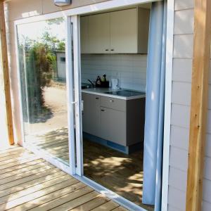 eine Küche mit einer Glasschiebetür, die auf eine Terrasse führt in der Unterkunft Storchencamp Gästehaus Rust in Rust