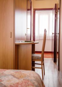 ein Schlafzimmer mit einem Bett, einem Tisch und einem Stuhl in der Unterkunft Aries in Lesa