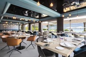 un ristorante con tavoli, sedie e finestre di Black Bass Hotel a Sevrier