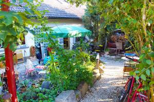 a garden with a green umbrella in front of a house at FREIraum in Küps